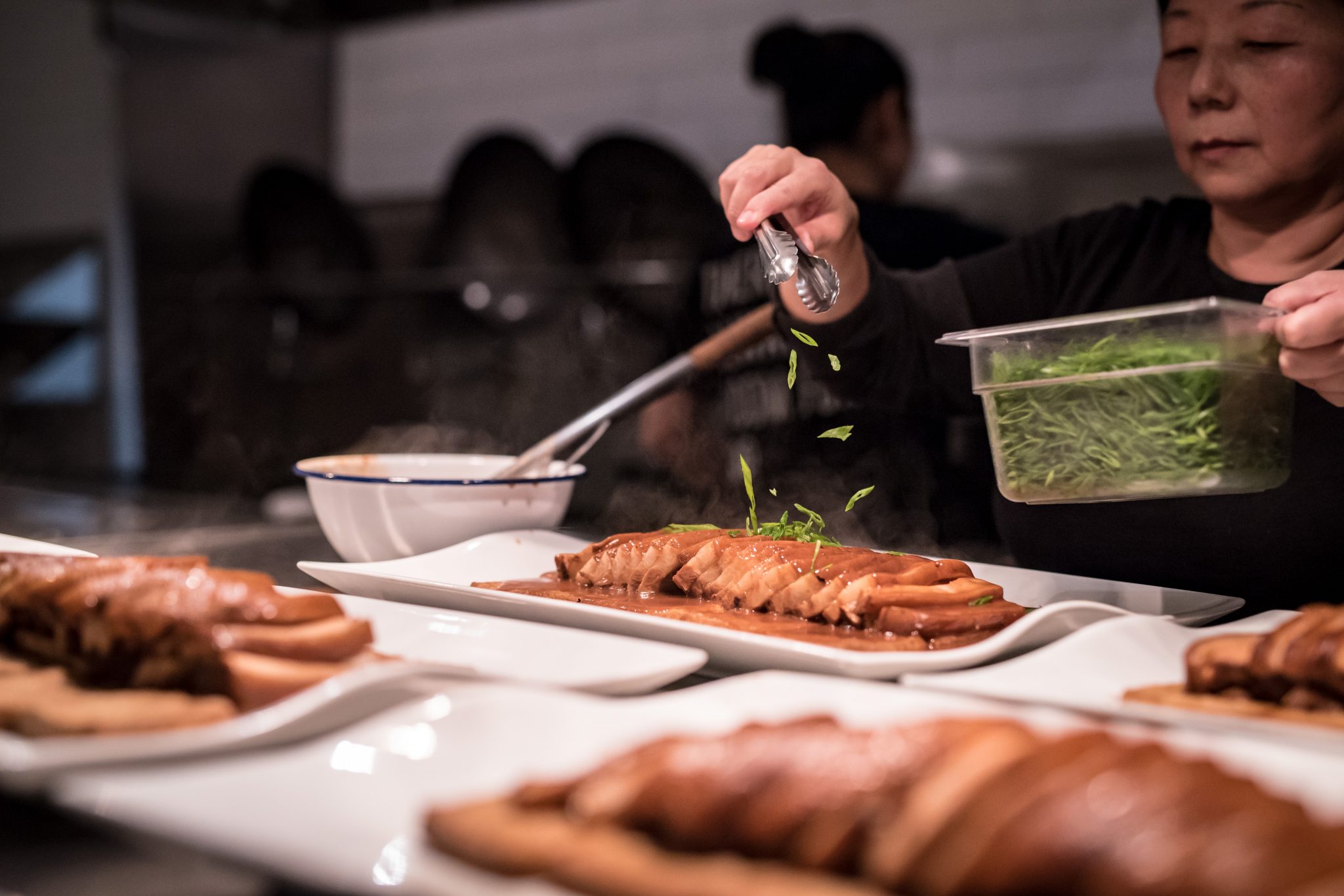 Lisa Zhang prepares the main dish for the Kitchen | Fields Table Tour's launch dinner.